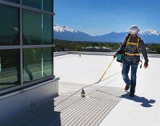 construction worker on roof wearing fall protection gear