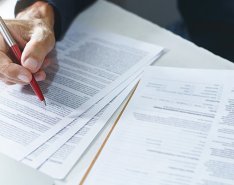 Person at desk signing paperwork