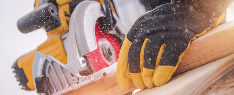 Gloved hands using power tool