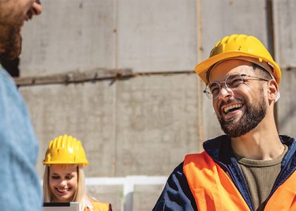 people in hard hats and vest smiling/Adobe Stock